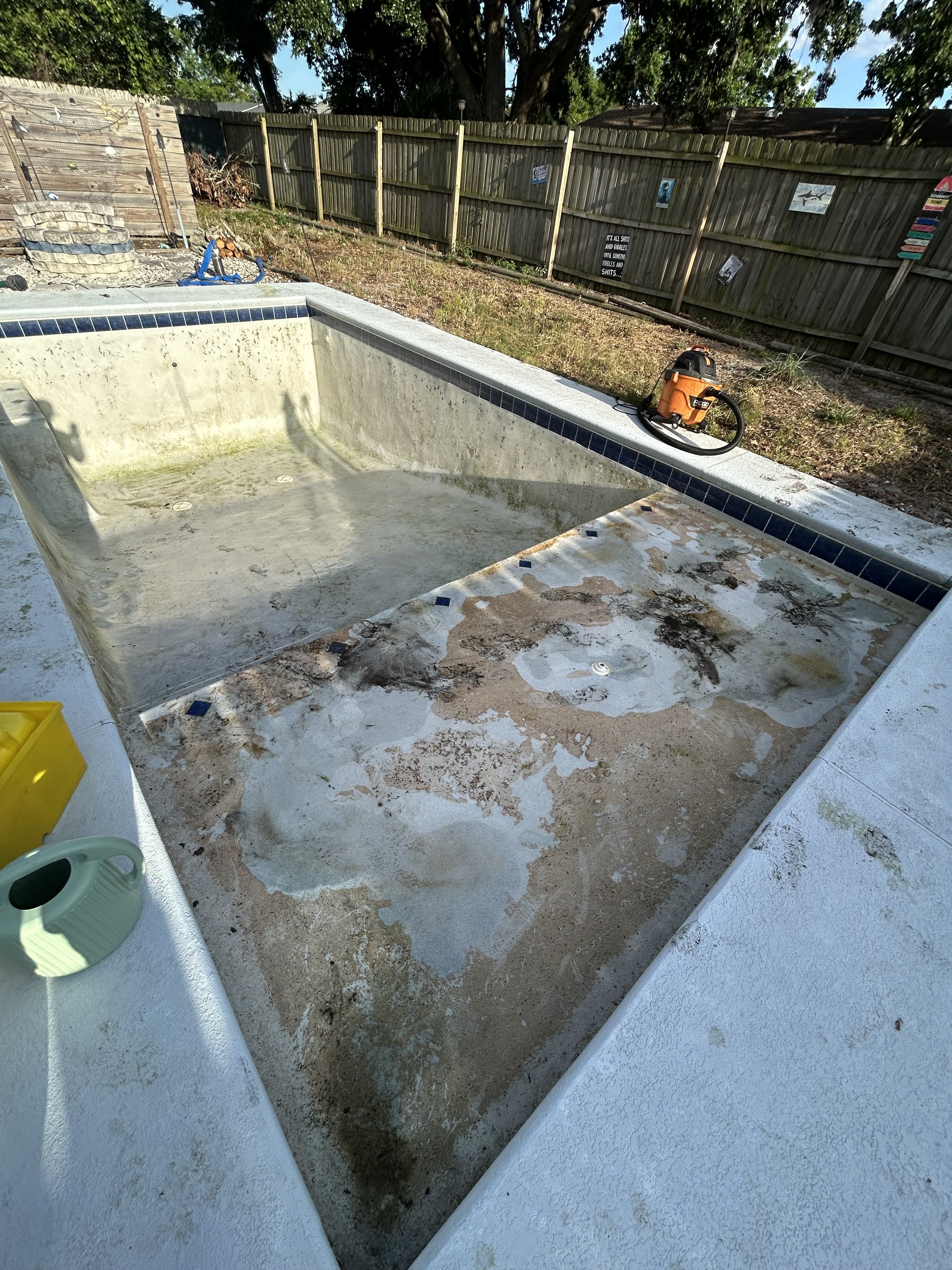 Acid wash pool service — drained pool floor being cleaned