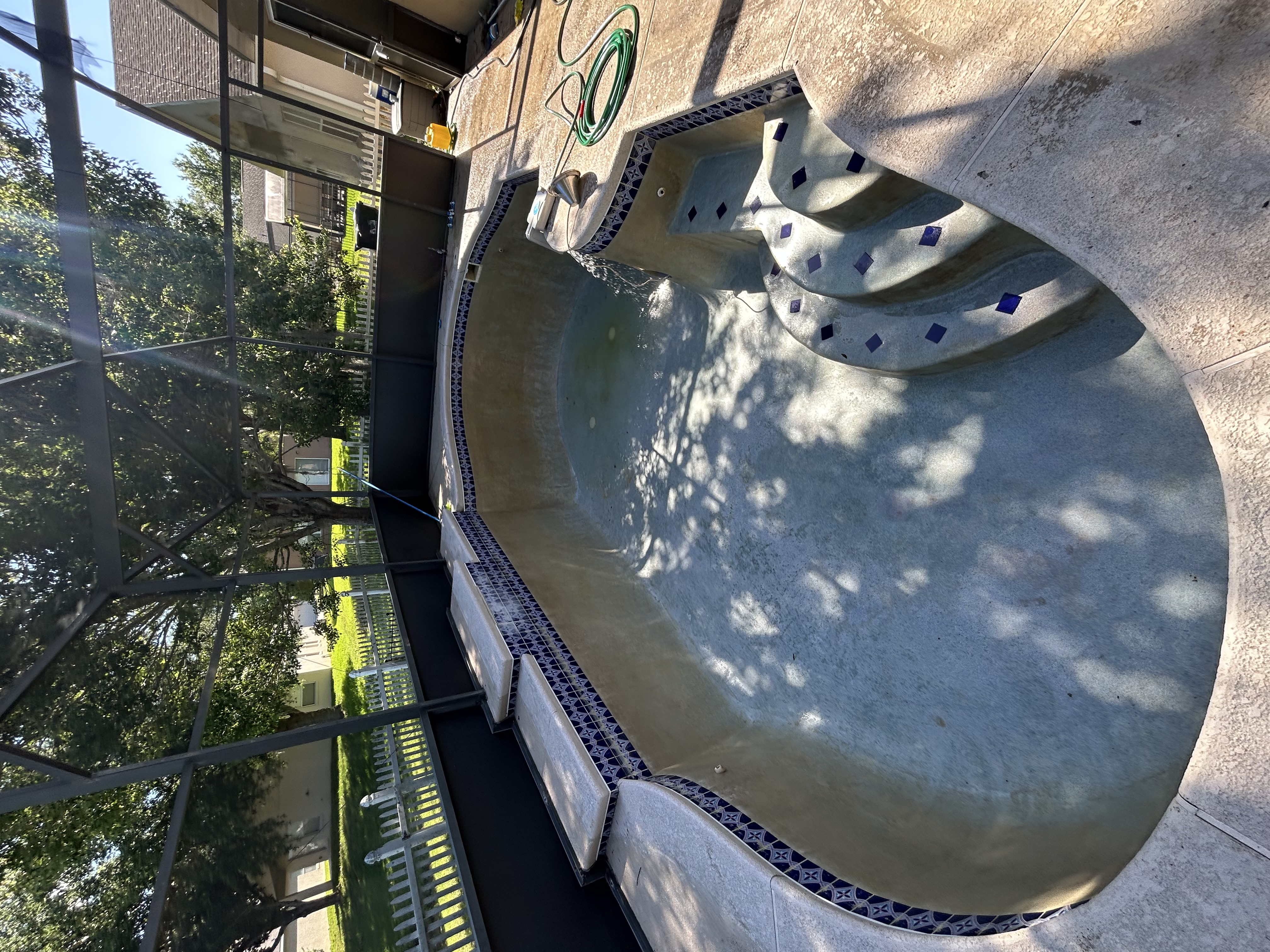 Swimming pool fully drained showing plaster and steps during a drain and clean in Central Florida
